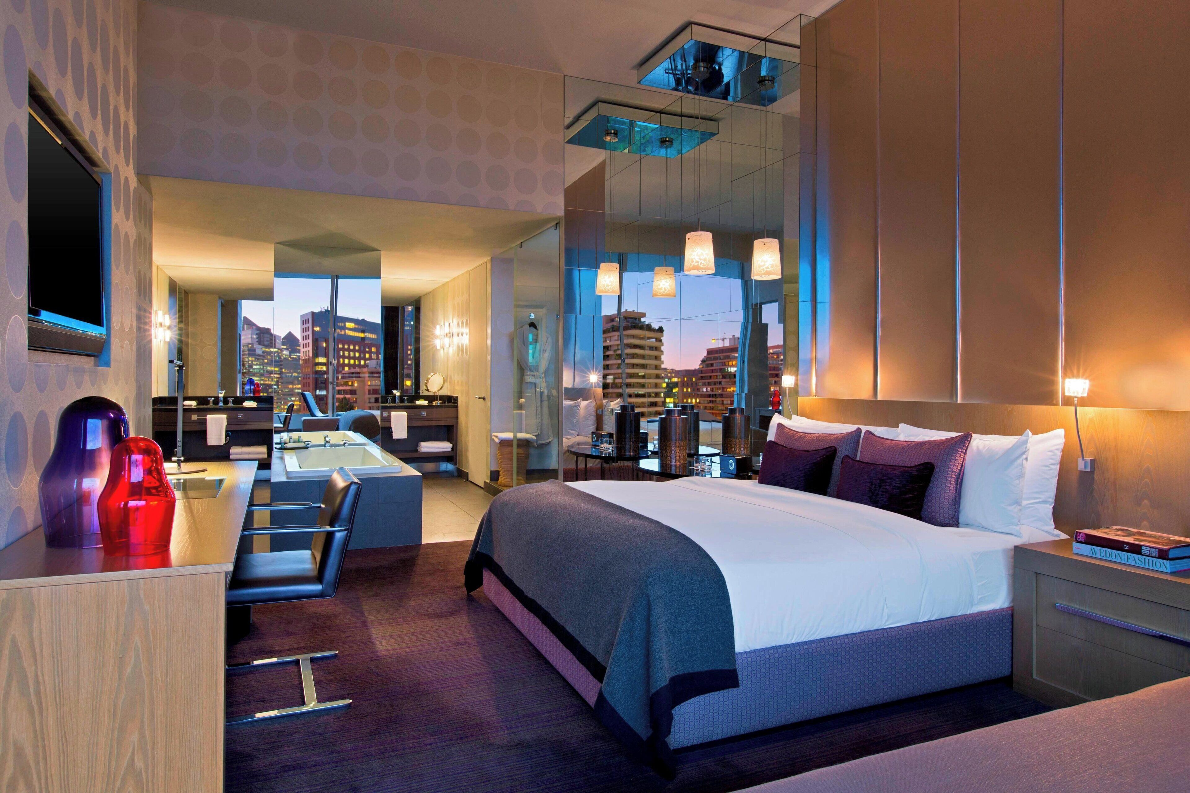 Une chambre d’hôtel moderne avec un grand lit, un bureau et une salle de bain.