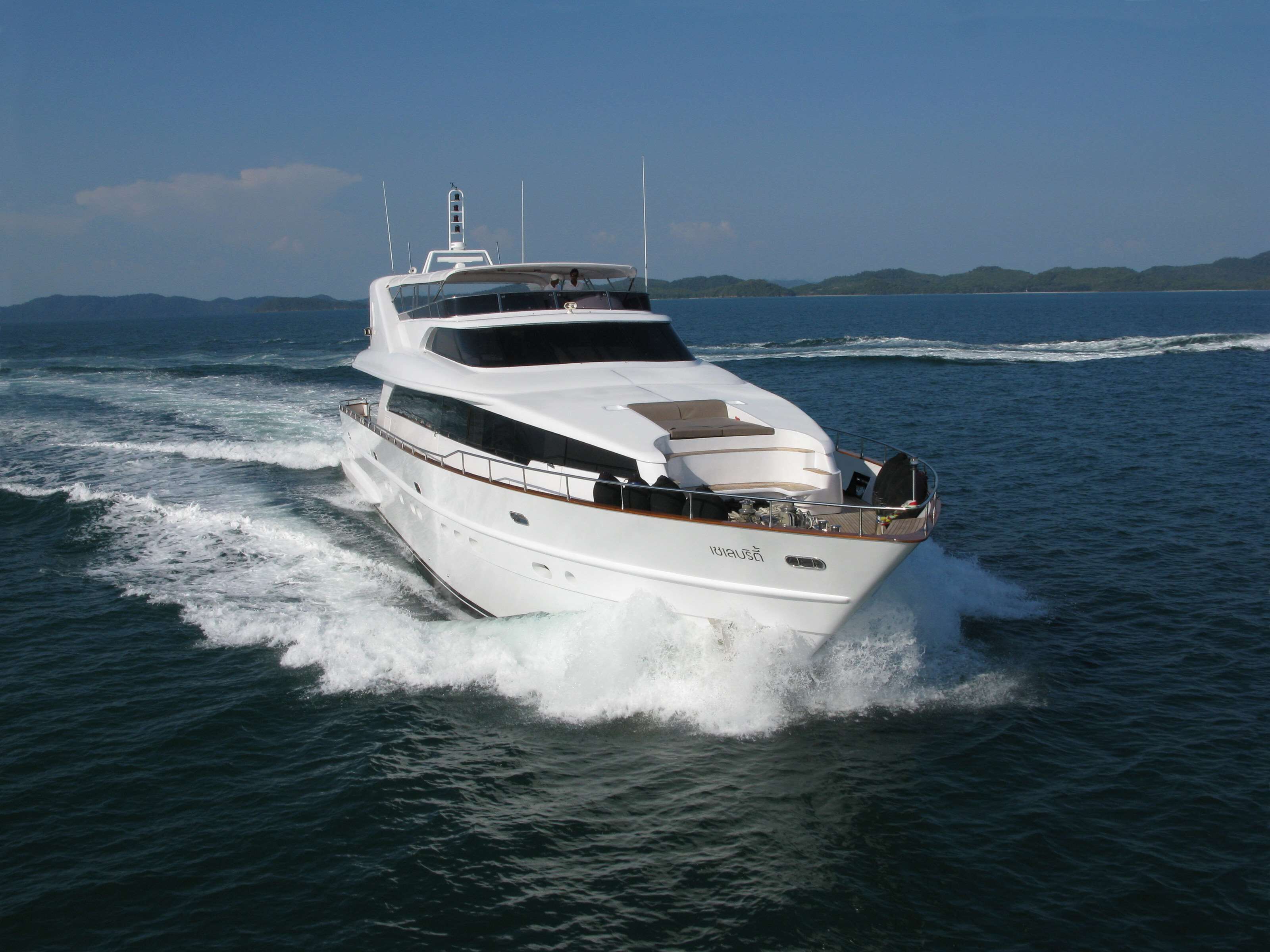 A large, multi-deck yacht cruising on open water.