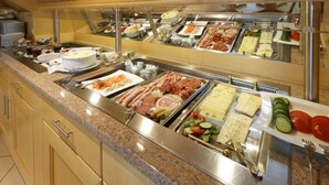 A buffet with various food options including meats, cheeses, and salads.