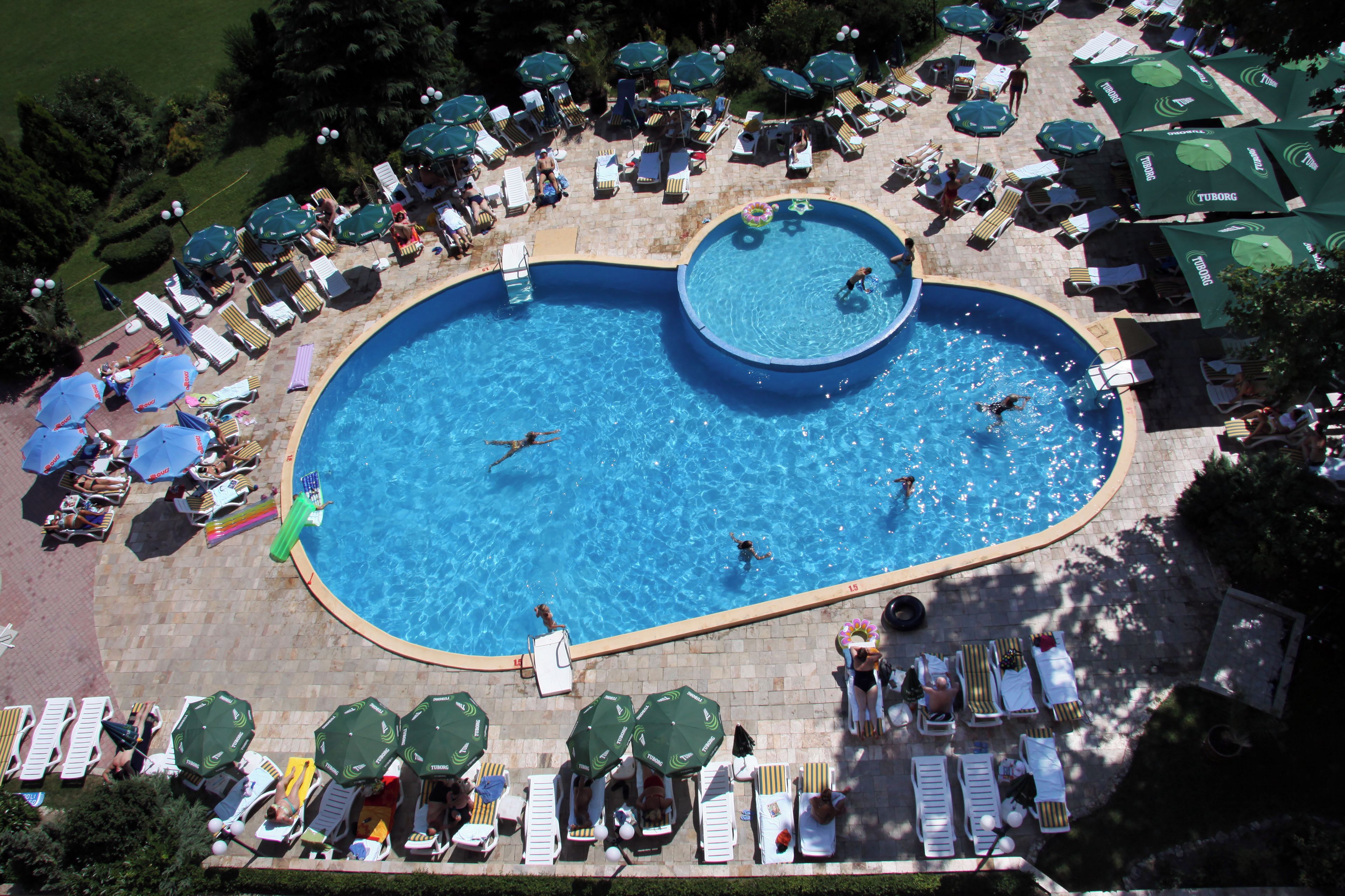 A large heart-shaped pool surrounded by lounge chairs and umbrellas.