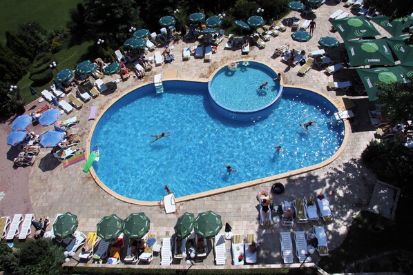 A large heart-shaped pool surrounded by lounge chairs and umbrellas. - Hotel Lilia (Varna)