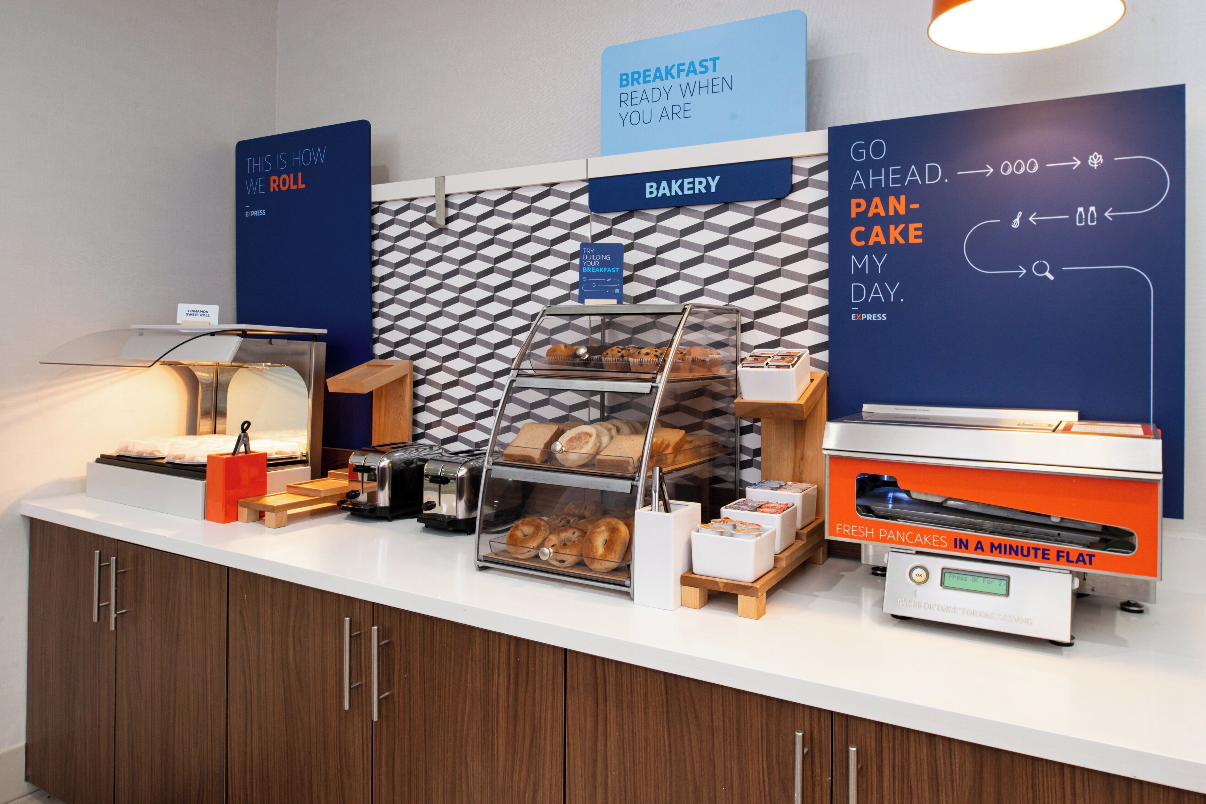 Um buffet de café da manhã com diversos alimentos e um aviso indicando a disponibilidade de panquecas frescas.