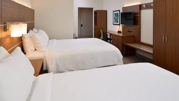 A hotel room with two beds, a desk, a chair, a TV, and a wardrobe.