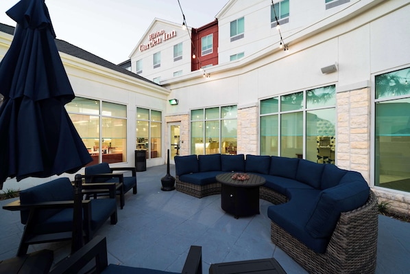 A patio area with outdoor seating, a wicker sofa, and a table.