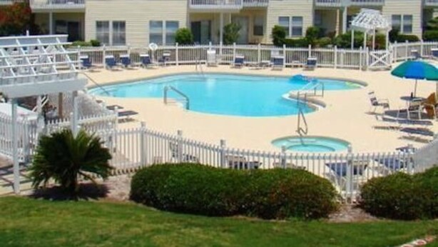 Ein Hotel mit Poolbereich, einschließlich Liegestühlen und Sonnenschirmen.