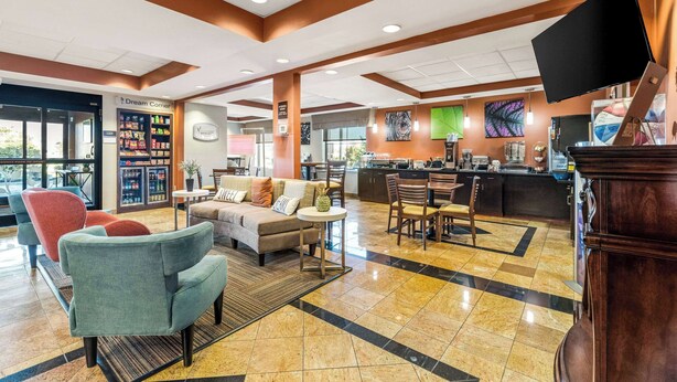 A hotel lobby with a seating area, a refreshment bar, and a large screen. - Sleep Inn & Suites Dyersburg I-155 (Dyersburg)