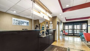 A reception area with a dark reception desk, a welcome mat, and a large window with a view of the outside. - Sleep Inn & Suites Dyersburg I-155 (Dyersburg)