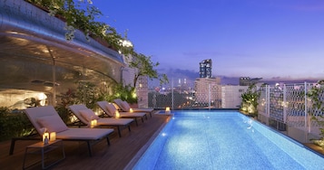 Una piscina al aire libre, sillones reclinables de piscina