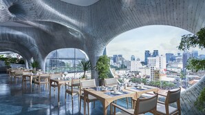 A modern restaurant with a unique architectural design featuring curved ceilings and large windows offering a city view. - Silverland Ben Thanh (Ho Chi Minh City)