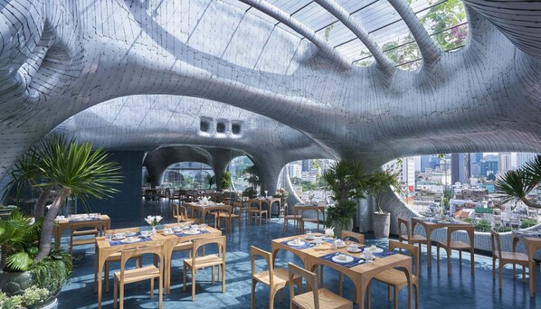 Um restaurante moderno com design de teto único e vista para a cidade.