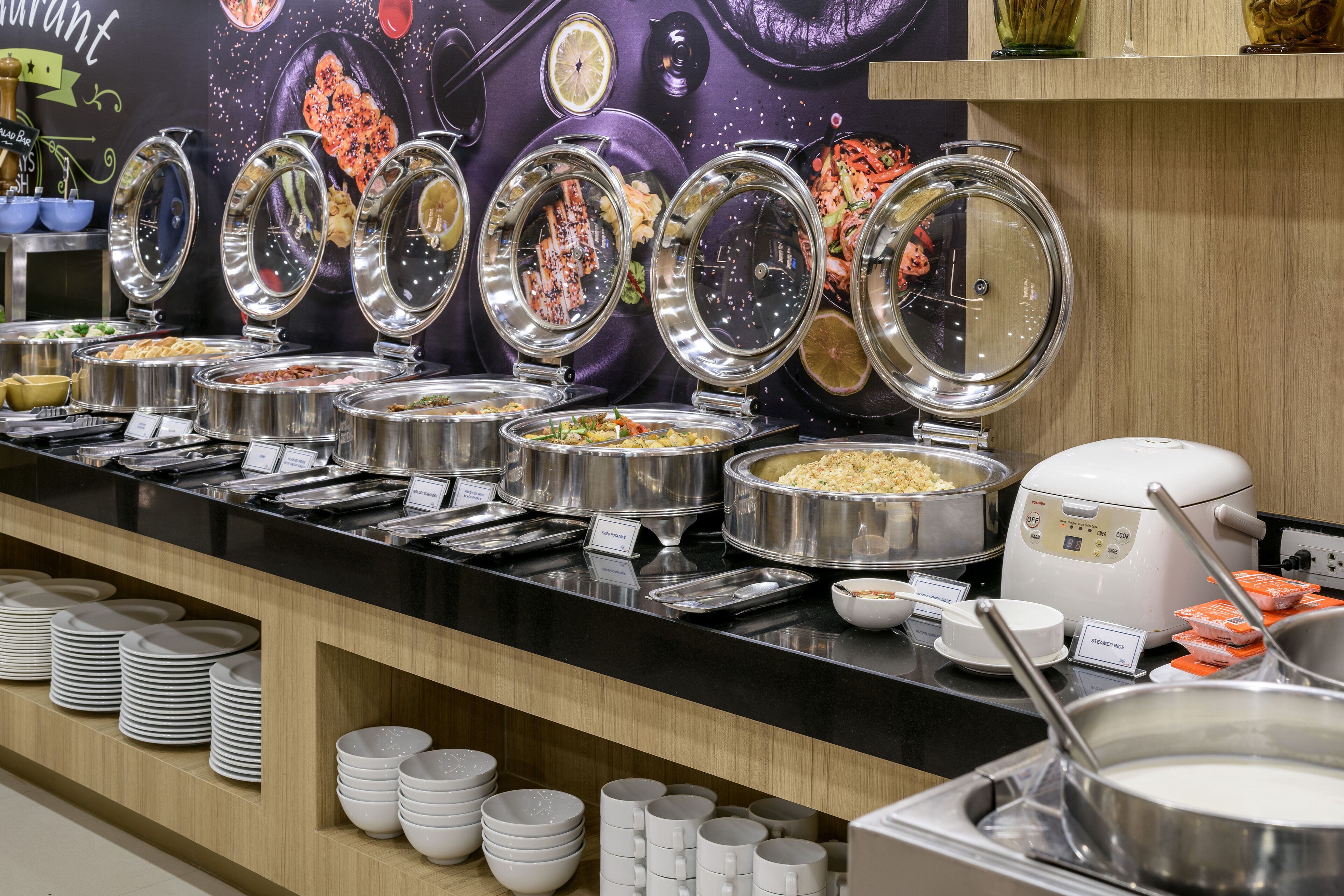 A buffet with various food items and utensils.