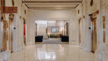 Un'hall dell'hotel con pavimenti in marmo, una scala e una reception.