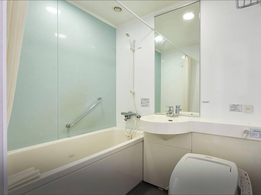 Un baño con bañera, lavabo, espejo e inodoro.