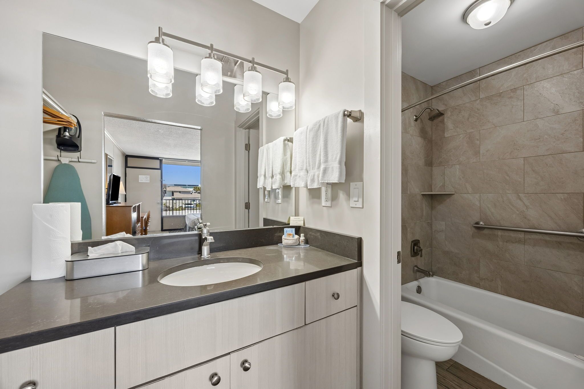 A modern bathroom with a sink, mirror, and shower.