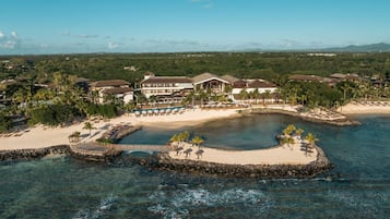 Un resort con un edificio grande, una playa y una laguna.