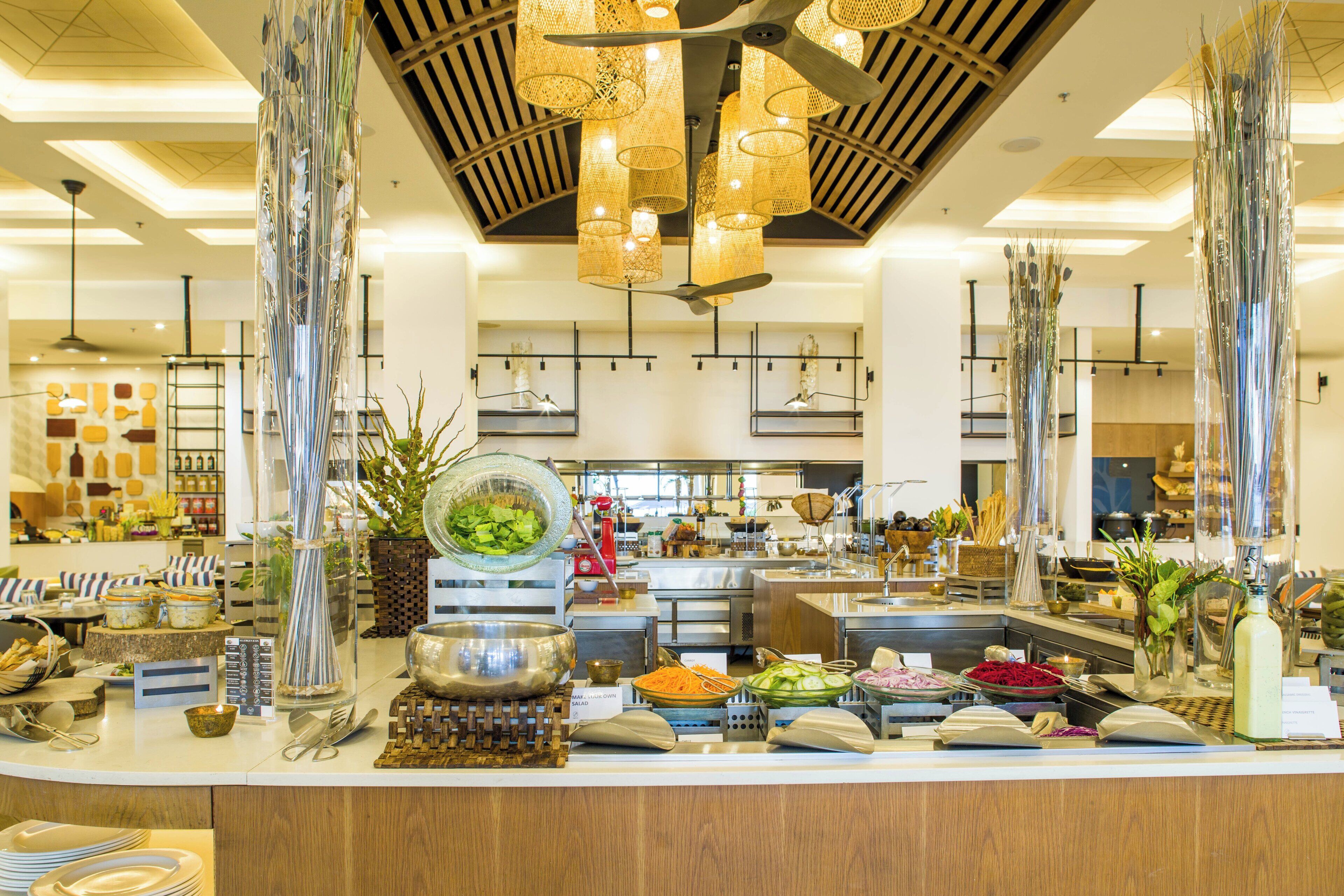 A buffet area with various food stations, including a salad bar and a fruit display.