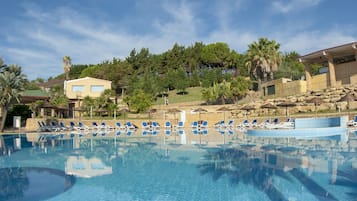 Una piscina al aire libre de temporada, sombrillas