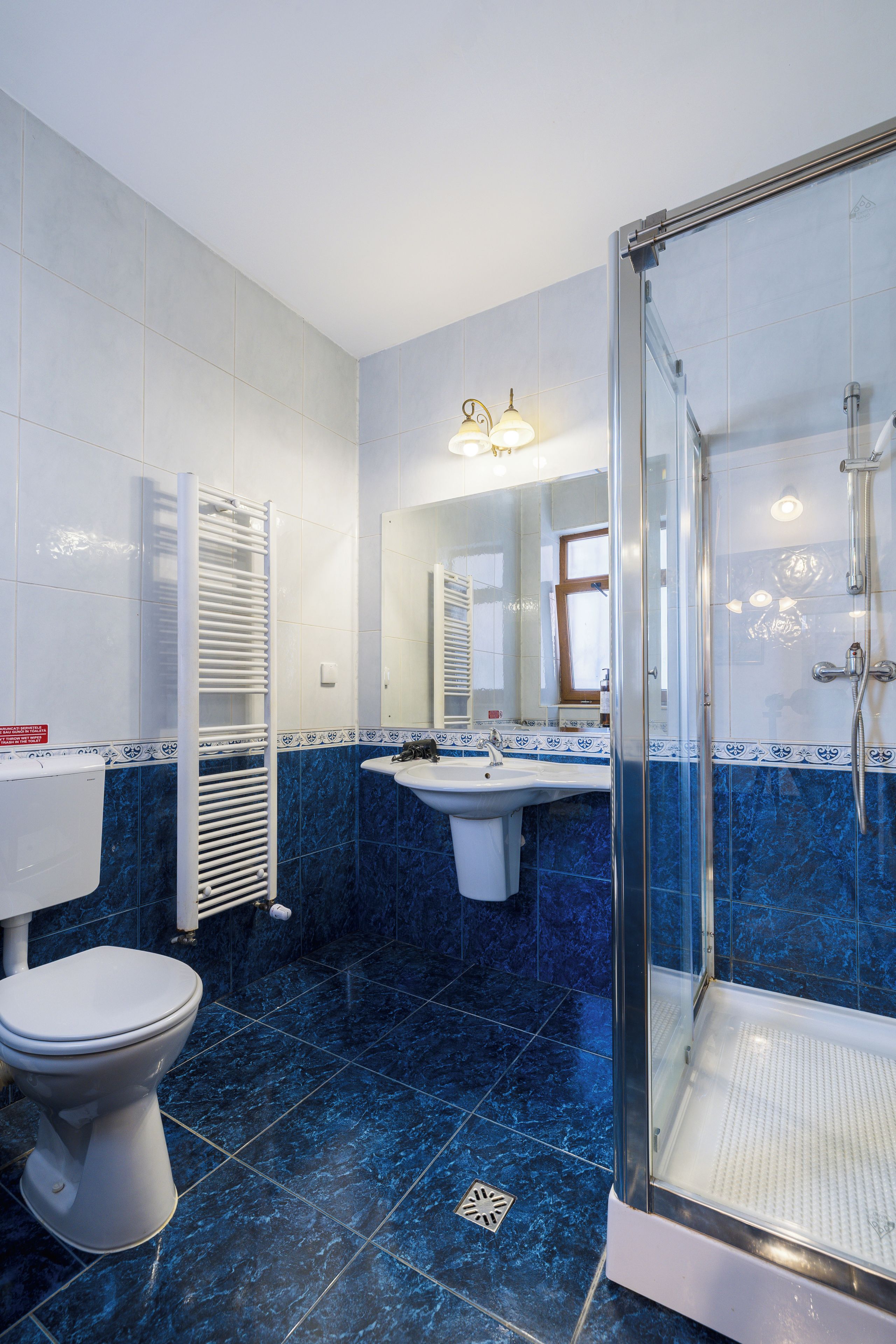 Un baño con inodoro, lavamanos y zona de ducha.