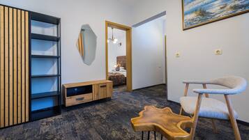 Een modern interieur met een houten kast, een bijzondere houten stoel, een schilderij aan de muur en een spiegel.