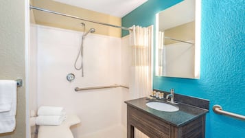 Une salle de bain avec une douche, un lavabo et un miroir.