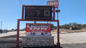 A Hillcrest Inn signboard with a digital display, indicating availability of rooms and suites. - Hillcrest Inn & Suites (Ozona)