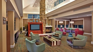 A spacious lobby with a fireplace, comfortable seating, and a large television. - Residence Inn by Marriott Waldorf (Waldorf)