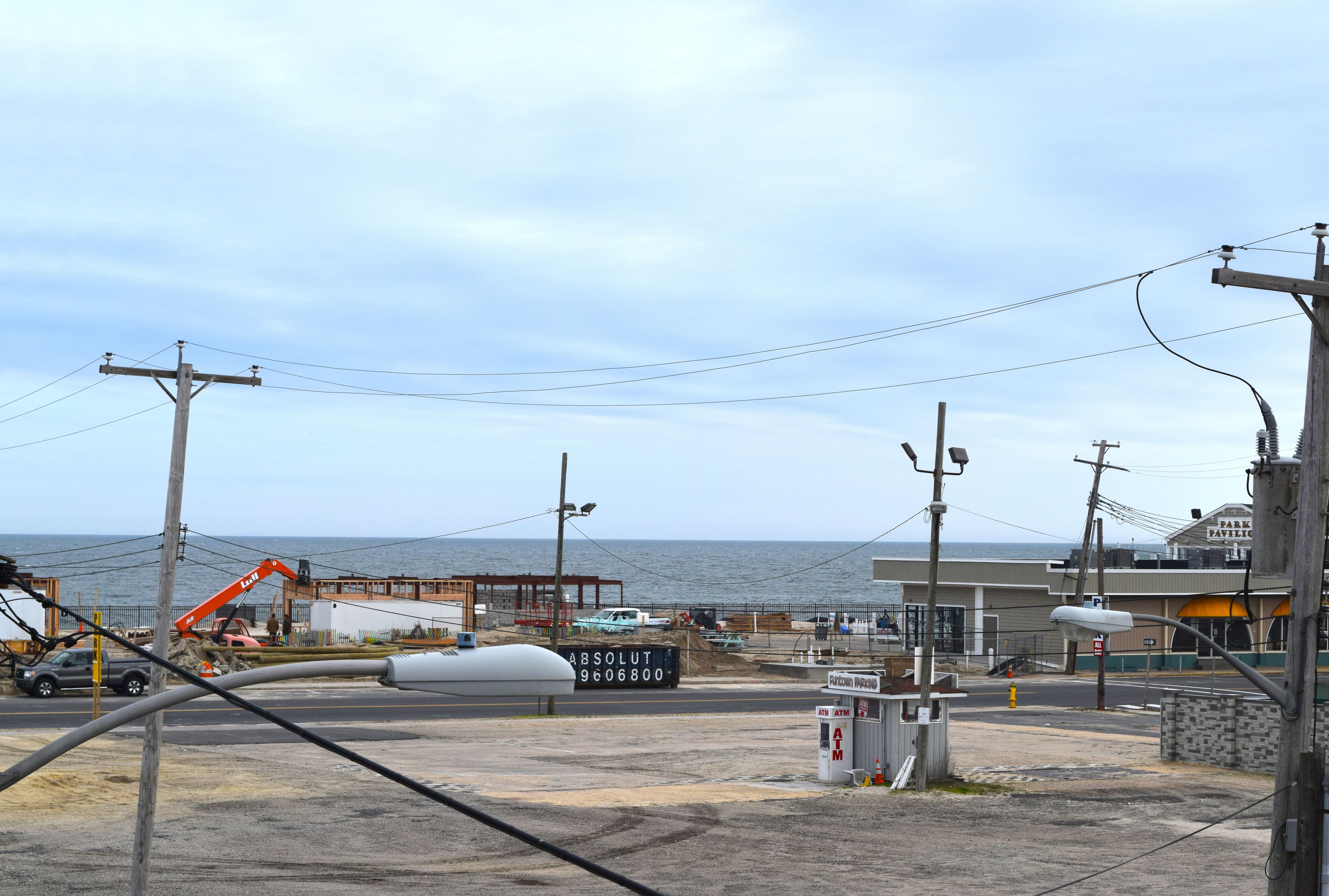 A coastal area with a gas station, a large white tank, and a construction site.