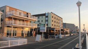Un paseo marítimo flanqueado por edificios, incluyendo un restaurante con terraza.