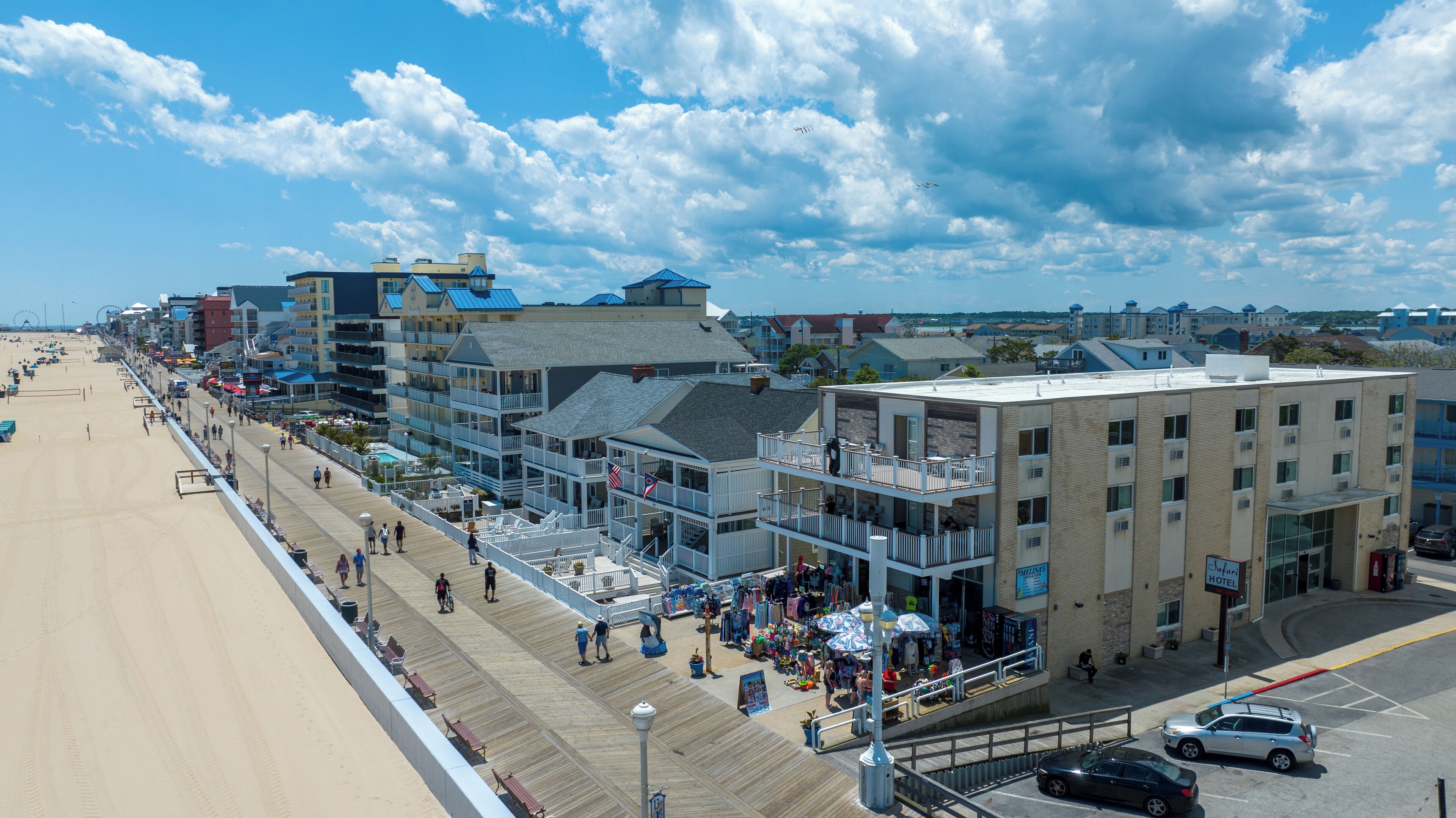 A beachfront hotel with multiple balconies, a boardwalk, and beach access.