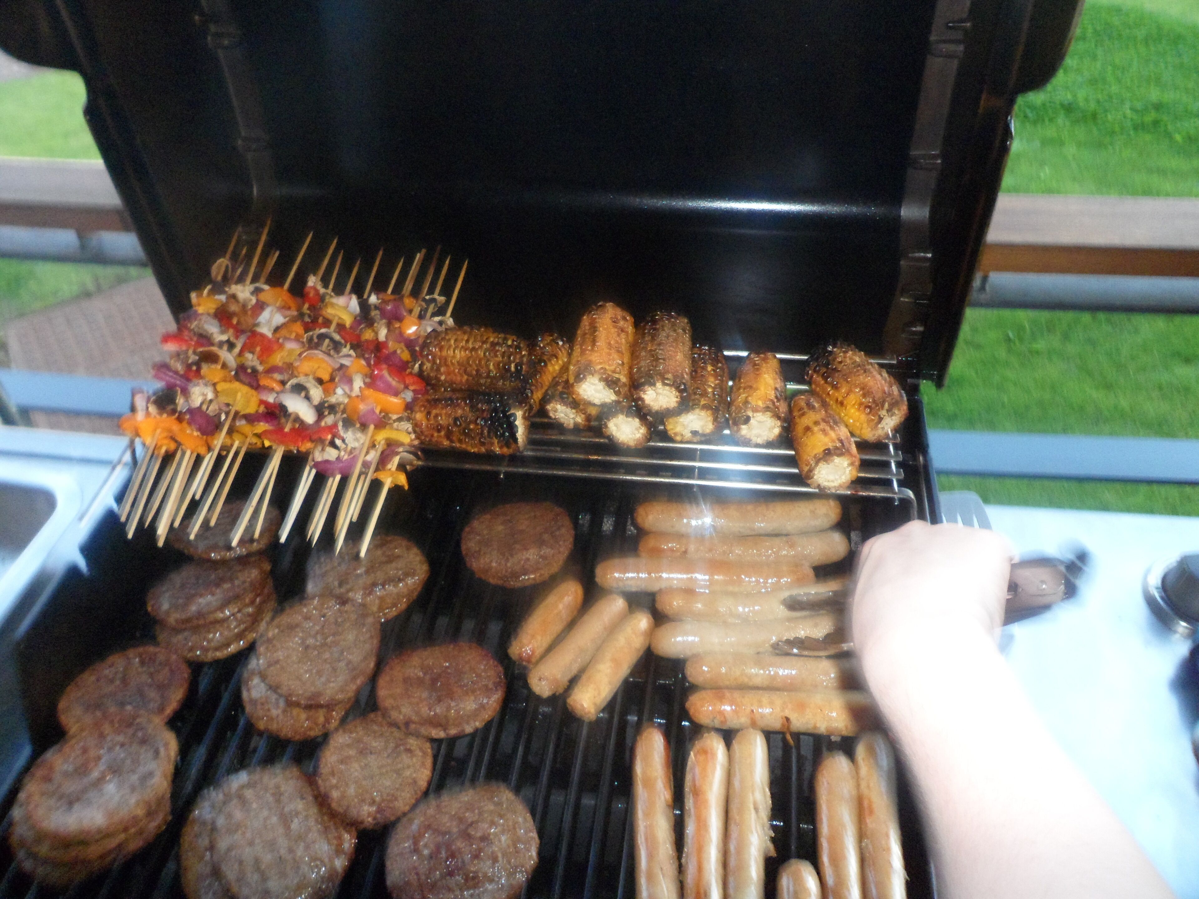 A grill with various meats and vegetables being cooked.