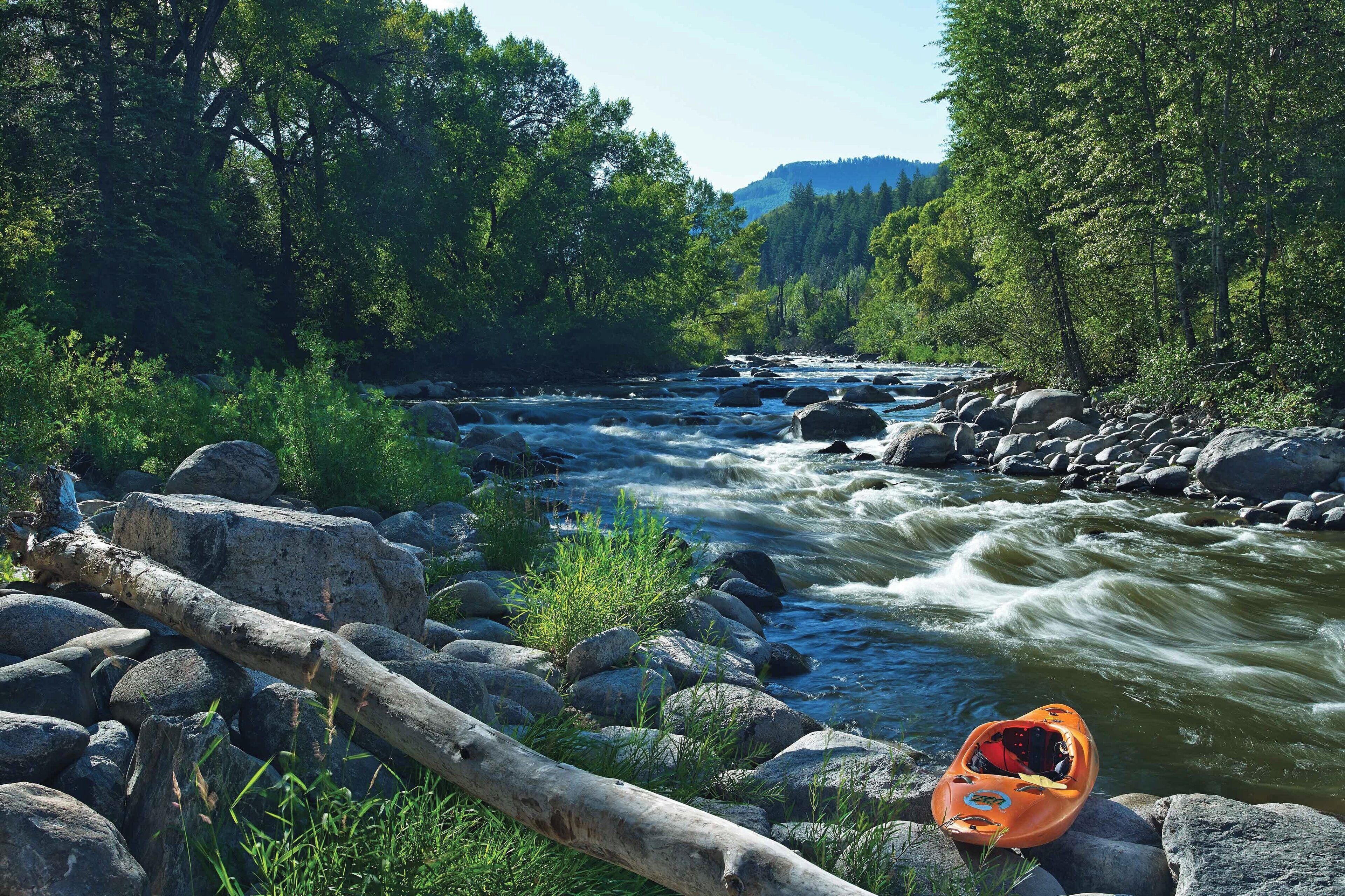 A river with rocks and a kayak.