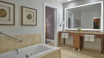 Un bagno moderno con vasca, doppio lavabo con specchio, opere d'arte incorniciate e zona doccia a vista.