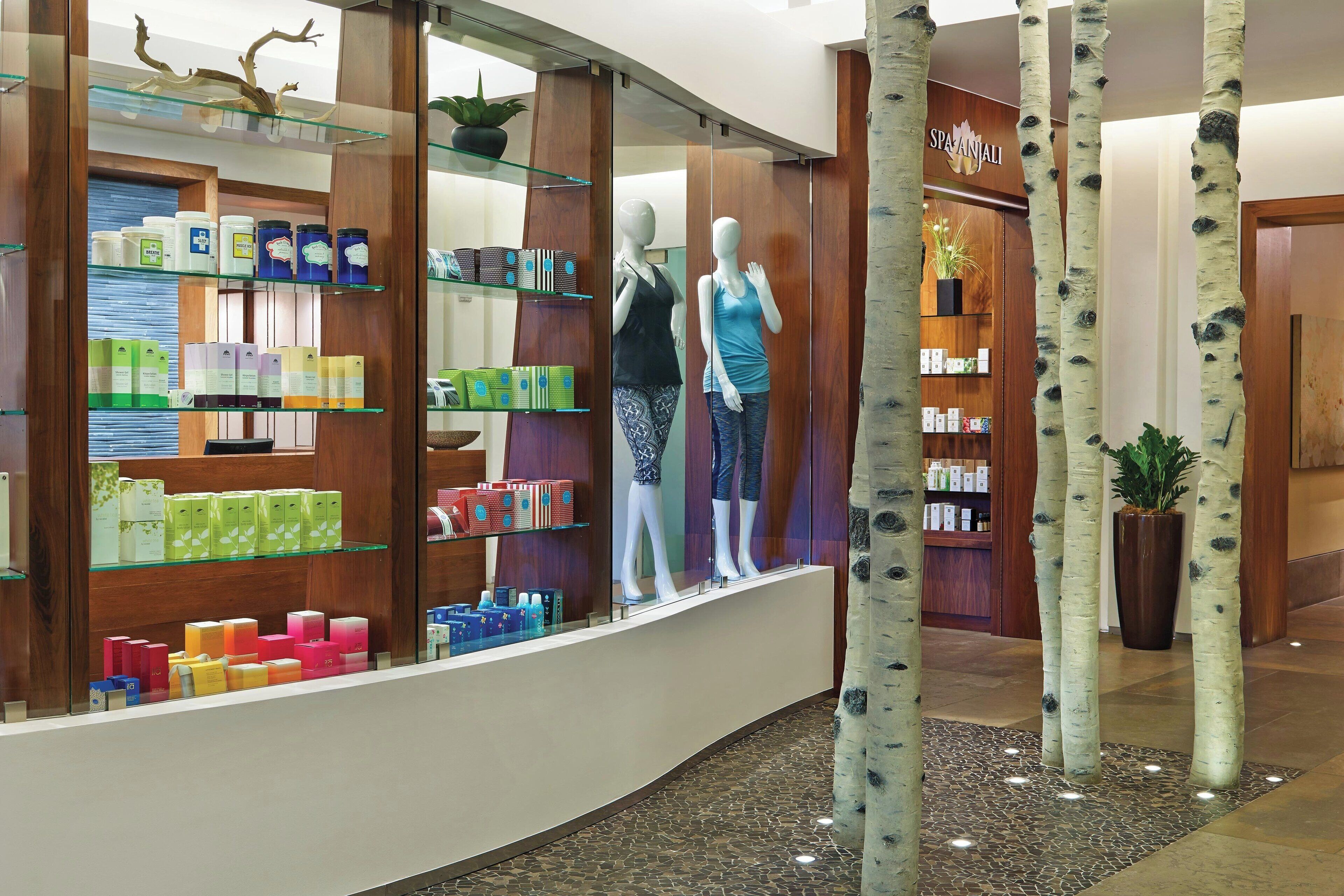 Un centro de spa y bienestar con una zona de recepción, exhibición de productos de bienestar y una planta en el vestíbulo.