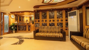 Um hall de entrada com uma mesa de recepção, um sofá e uma parede estampada.
