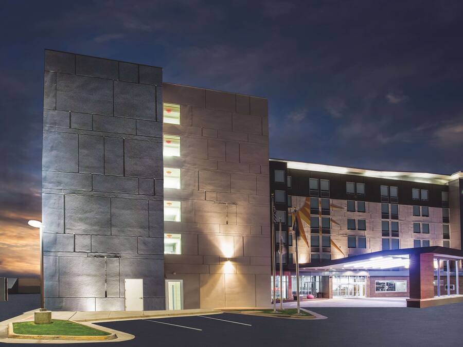 A modern hotel with a flat facade, multiple windows, and a well-lit entrance.