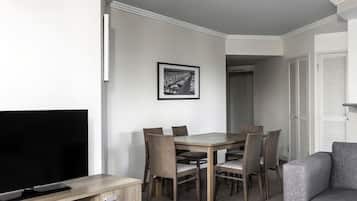 Una sala de estar moderna con un televisor de pantalla plana, una mesa de comedor de madera y seis sillas.