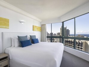 A hotel room with a large bed, a nightstand, a window with a city view, and a ceiling light. - Mantra Crown Towers (Surfers Paradise)