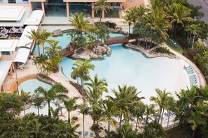 A resort with a large central pool, palm trees, and a bridge connecting different areas. - Mantra Crown Towers (Surfers Paradise)