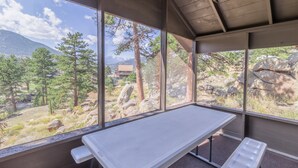 Una habitación con un amplio ventanal que ofrece vistas a un paisaje montañoso y árboles.