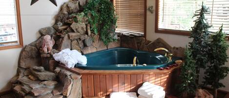 A stone wall, a wooden bathtub, and a small tree.