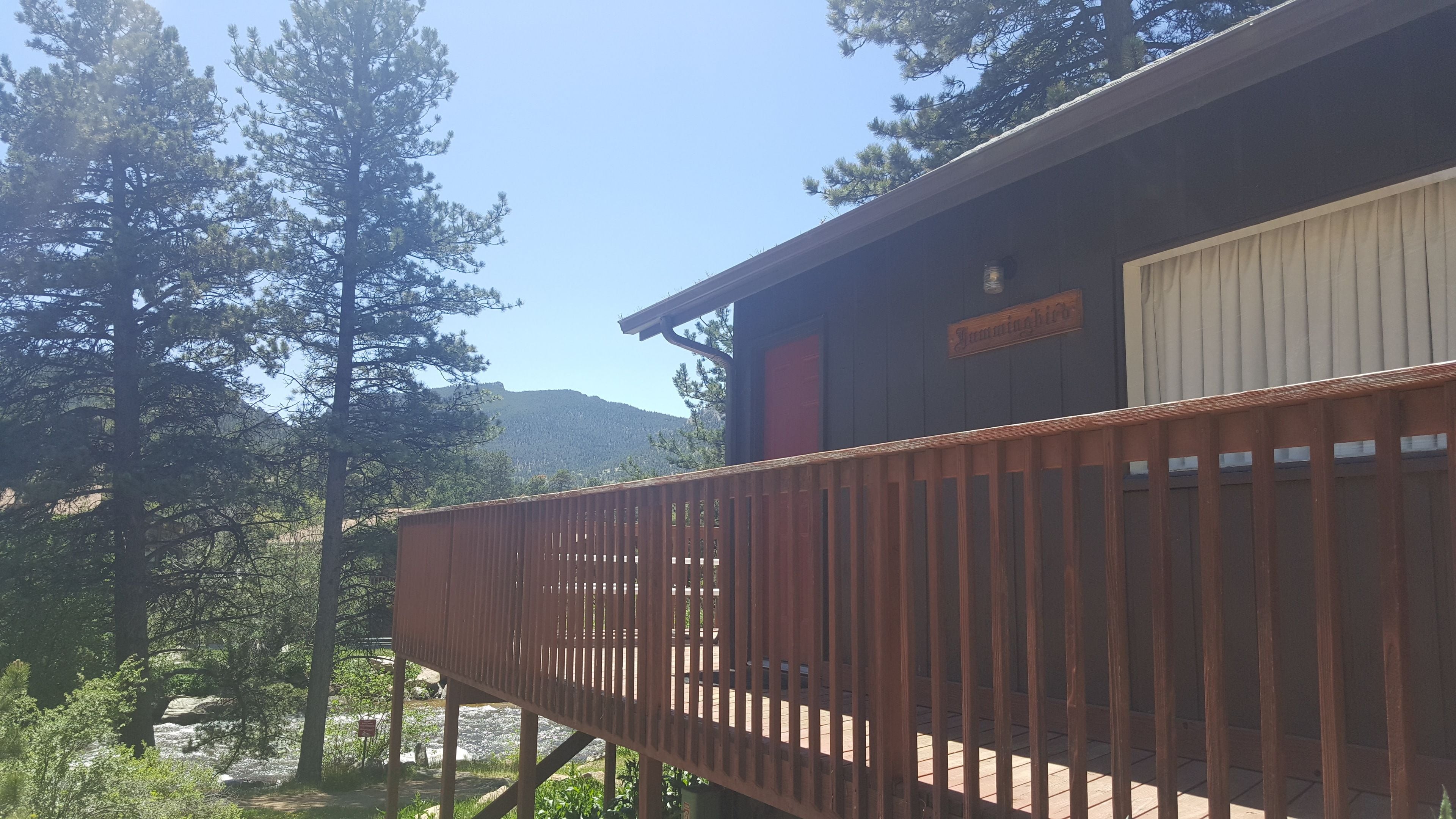 A wooden deck with a view of a mountain and trees.