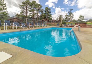Una piscina al aire libre de temporada, tumbonas