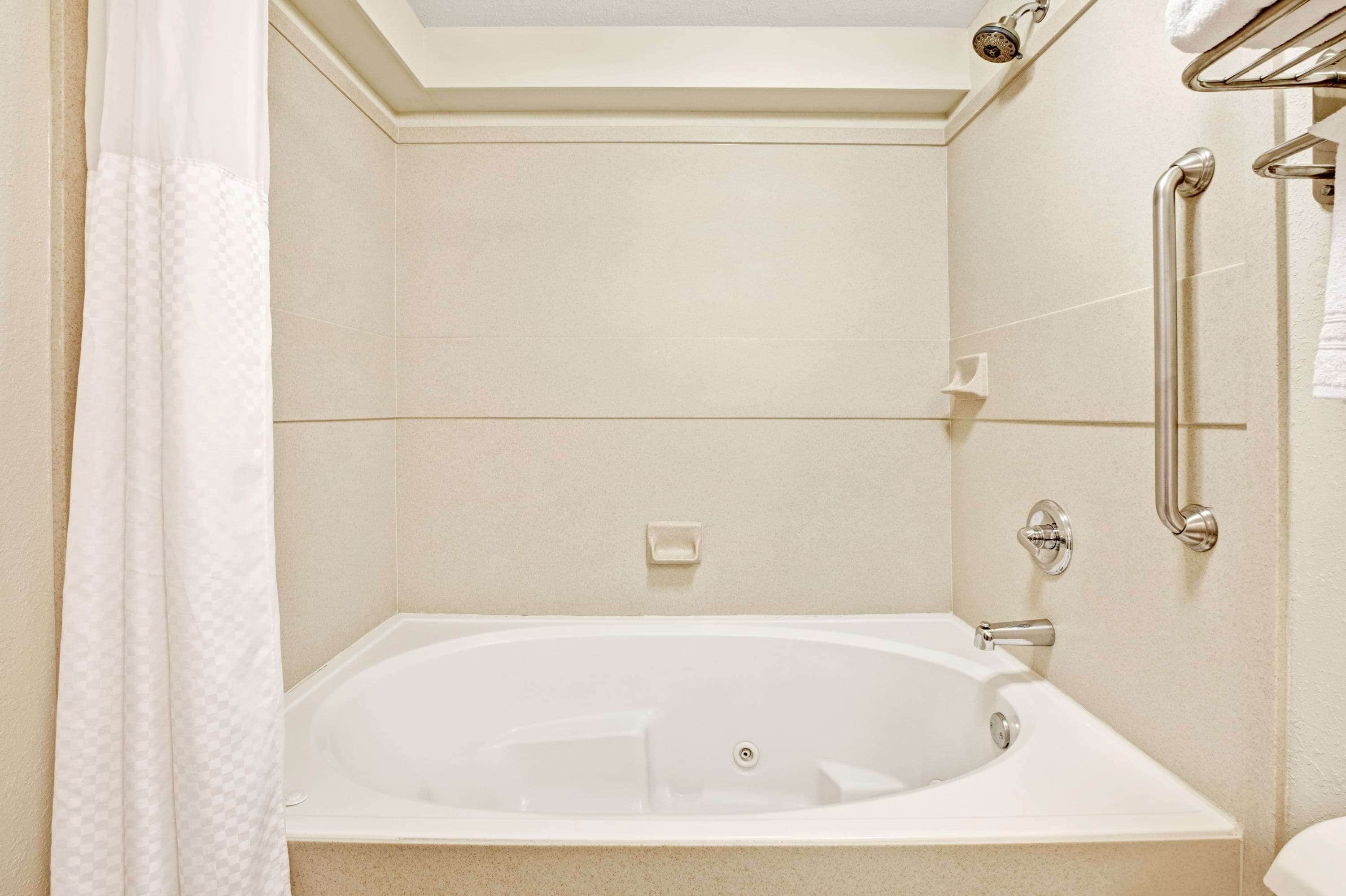 A modern bathroom with a freestanding bathtub, a shower with a handheld showerhead, and a towel rack.
