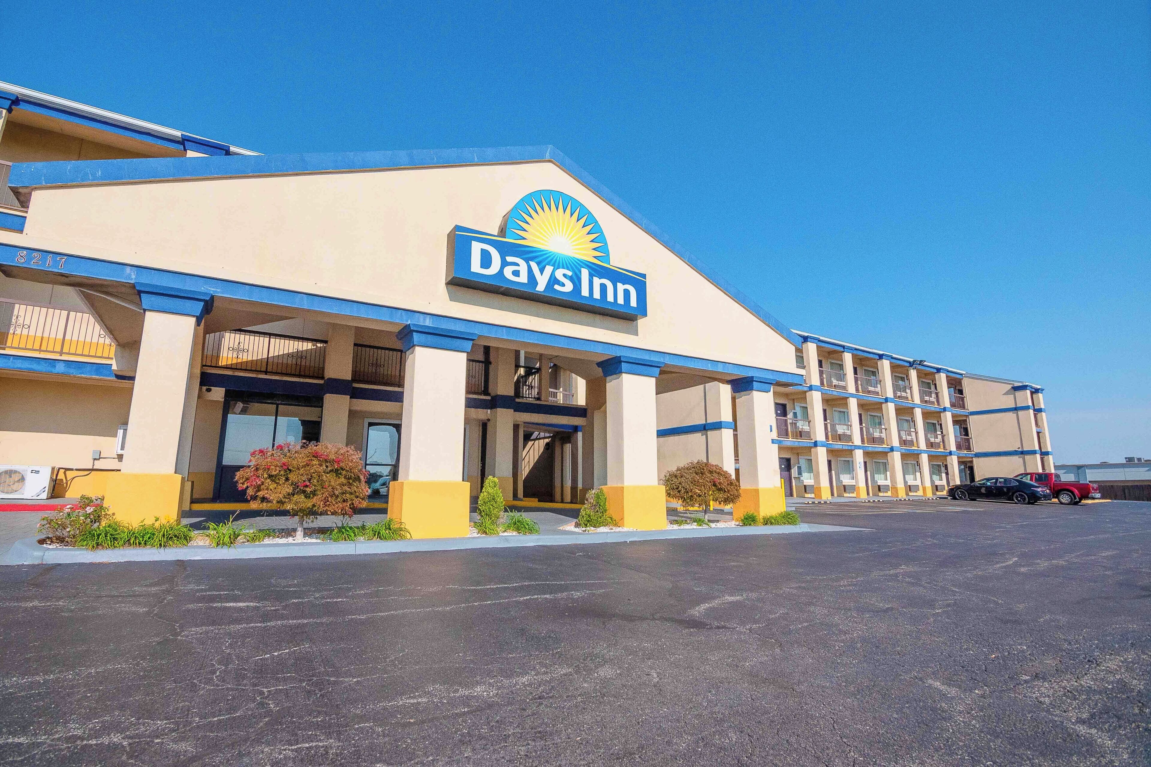 A Days Inn hotel with a large parking lot and a clear blue sky.