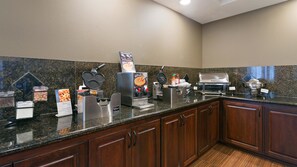 Une cuisine d’hôtel équipée d’appareils à gaufres, d’une machine à café et d’un buffet.