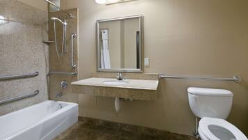 A bathroom with a bathtub, a sink with a mirror, and a toilet.