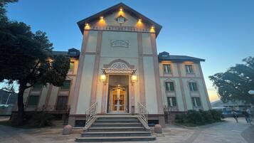 A building with a central entrance, steps leading up to it, and a sign above the entrance.