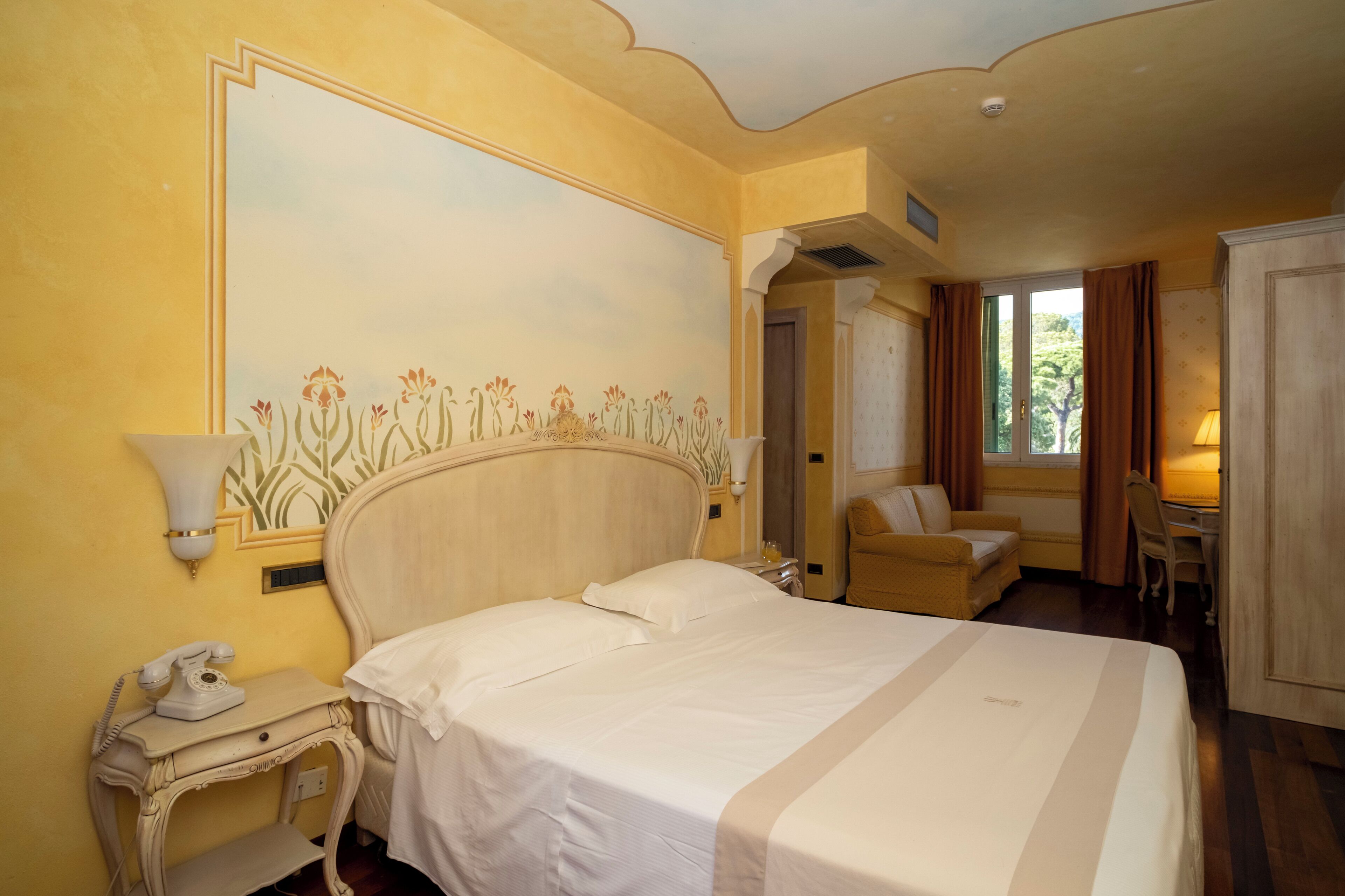 Una habitación de hotel con una cama grande, un escritorio, una silla y un armario.