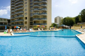 Una piscina cubierta, una piscina al aire libre, sombrillas, tumbonas