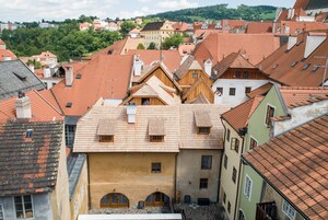 Un pueblo europeo tradicional con edificios apretados y techos empinados, mostrando una mezcla de estilos arquitectónicos.